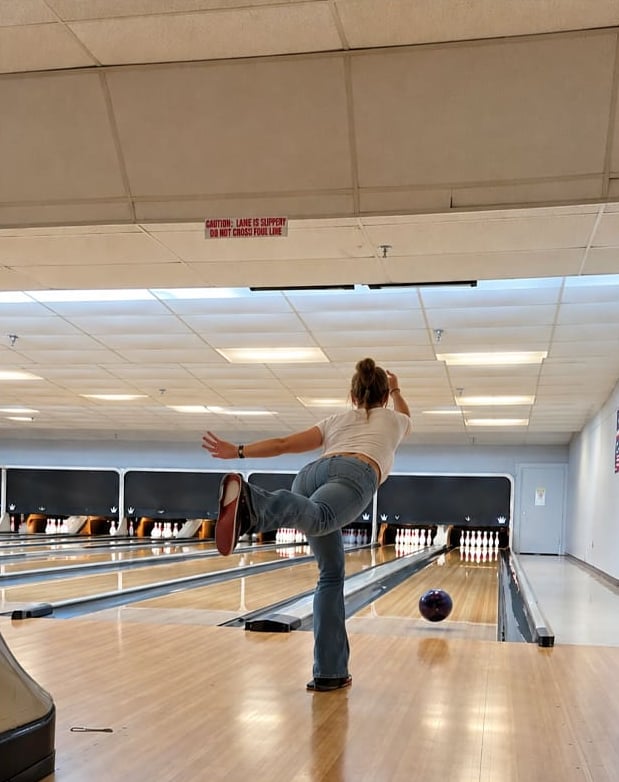 A guest mid-delivery at the bowling lanes